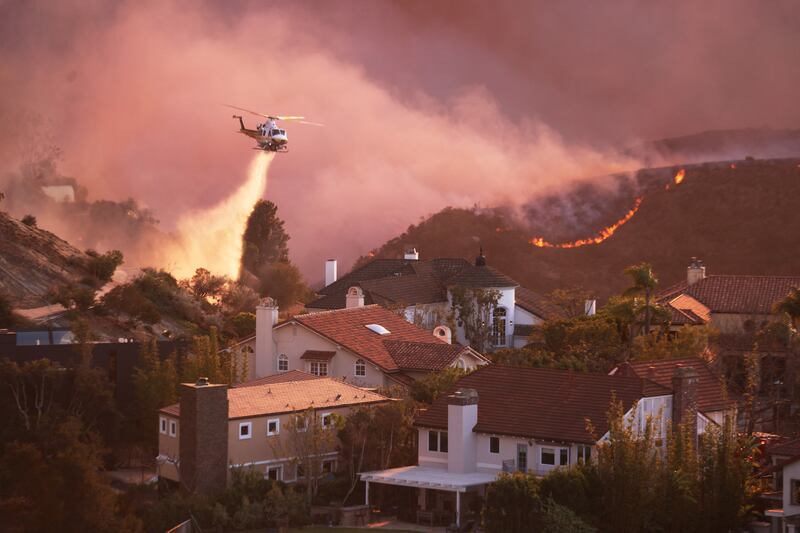 A helicopter fights the wildfire in Los Angeles County