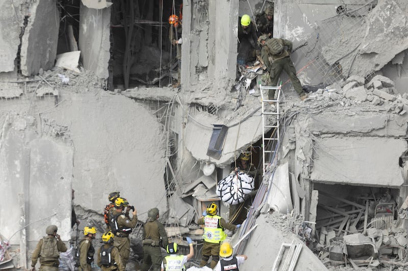 Rescue workers respond to a collapsed building hit by an Iranian missile in Beersheba, Israel, killing four people.