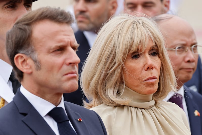 France's President Emmanuel Macron (L) and his wife Brigitte Macron take part in a wreath-laying ceremony at the monument of national heroes and martyrs in Hanoi