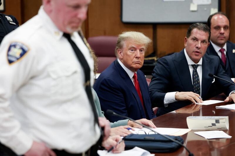 Former U.S. President Donald Trump sits in the courtroom with his attorneys Joe Tacopina and Boris Epshteyn (R) during his arraignment at the Manhattan Criminal Court April 4, 2023 in New York City.