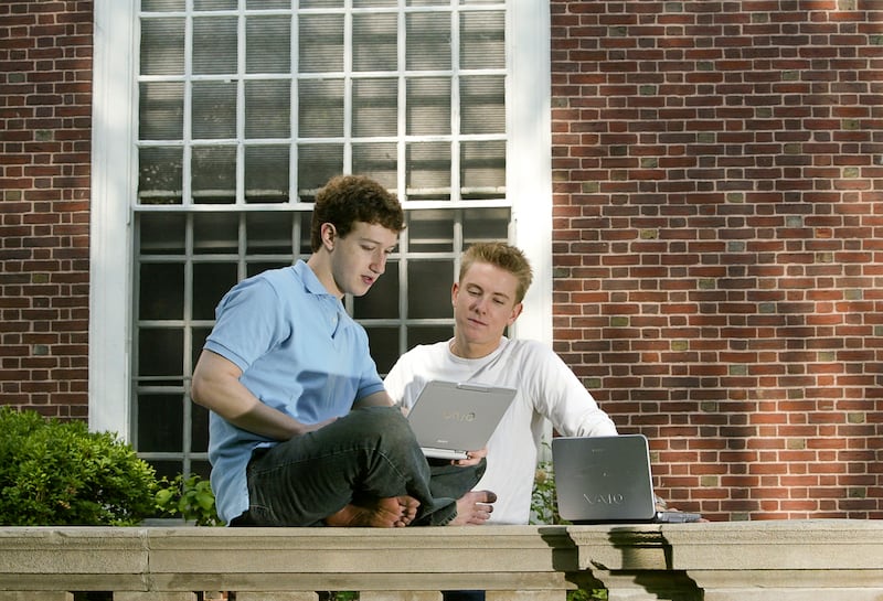 Facebook creators Mark Zuckerberg and Chris Hughes pose outside Eliot House at Harvard University on May 14, 2004.