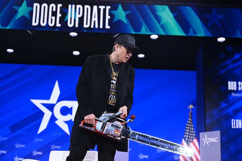 Billionaire Elon Musk, the head of the Department of Government Efficiency (DOGE), holds a chainsaw as he speaks at the annual Conservative Political Action Conference (CPAC) at the Gaylord National Resort & Convention Center at National Harbor in Oxon Hill, Maryland, on February 20, 2025. The chainsaw was a present to Elon Musk from Argentina's President Javier Milei. (Photo by SAUL LOEB / AFP) (Photo by SAUL LOEB/AFP via Getty Images)