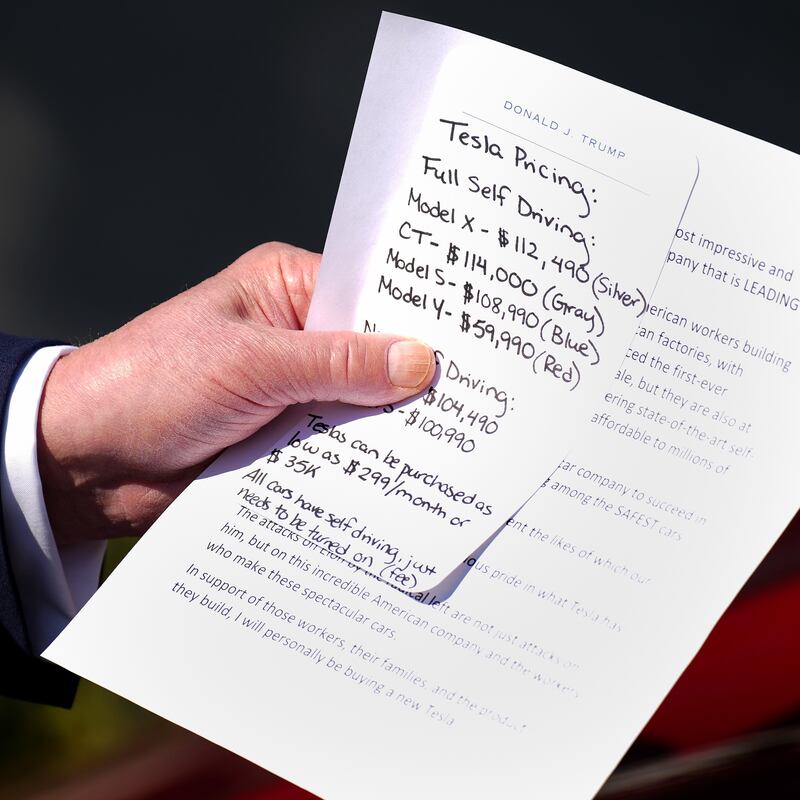 Donald Trump carried a note that included Tesla pricing during his White House stunt where he purchased a new car he says he will never drive.