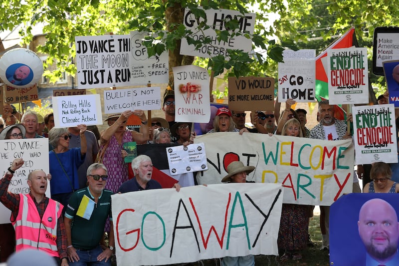 Protestors pose with placards at a "Vance Not Welcome Party" in Charlbury.