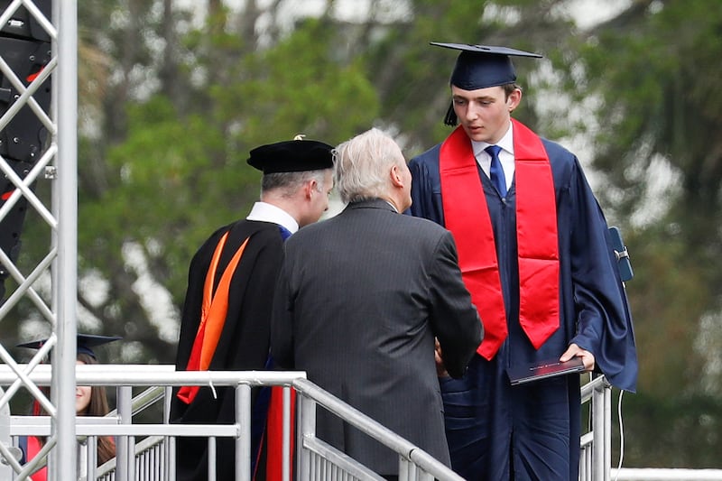 Barron Trump in graduation robe and hat