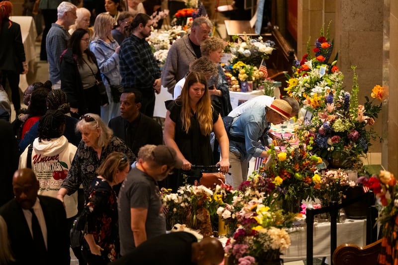 People view a memorial outside the House Chambers as Rep. Melissa Hortman, her husband Mark Hortman, and their dog Gilbert lie in state.