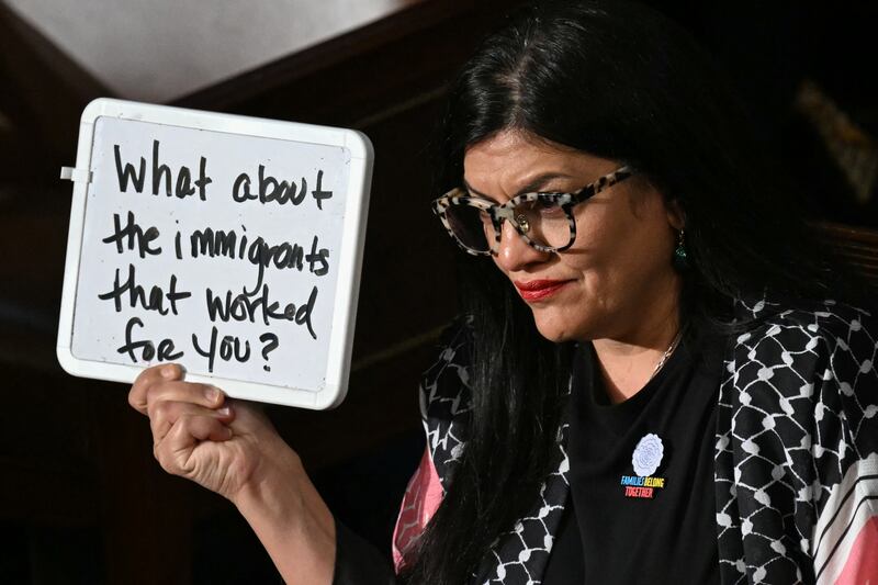 US Representative Rashida Tlaib (D-MI) holds up a white board reading "What about the immigrants that worked for you?" as US President Donald Trump speaks during an address to a joint session of Congress in the House Chamber of the US Capitol in Washington, DC, on March 4, 2025.