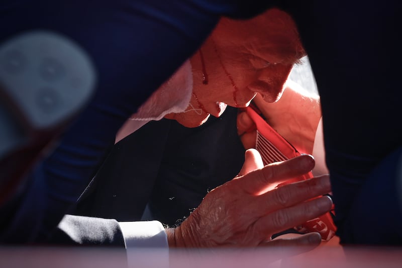 Republican presidential candidate former President Donald Trump is shown covered by U.S. Secret Service agents after an incident during a rally on July 13, 2024 in Butler, Pennsylvania