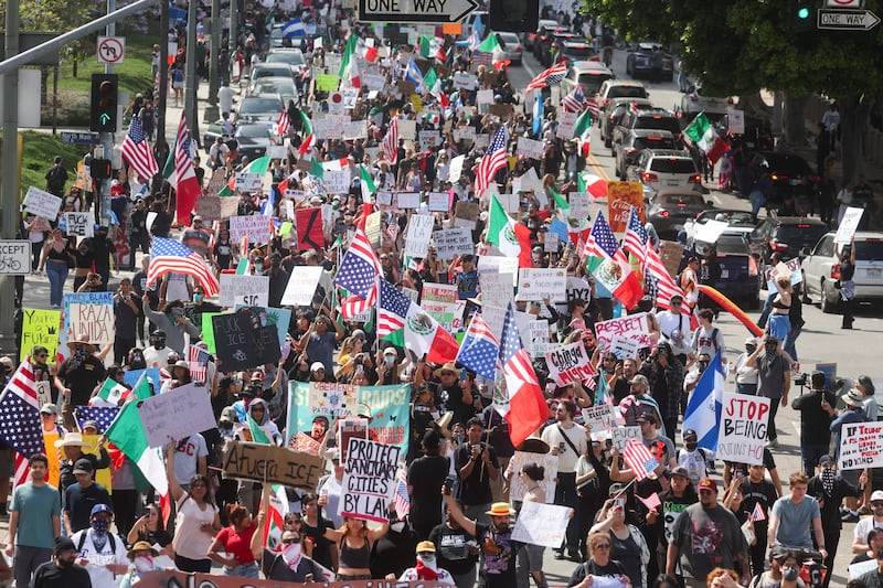 Demonstrators holding signs and flags participate in a "No Kings" protest against U.S. President Donald Trump's policies and federal immigration sweeps, in Los Angeles, California, U.S., June 14, 2025. REUTERS/Pilar Olivares