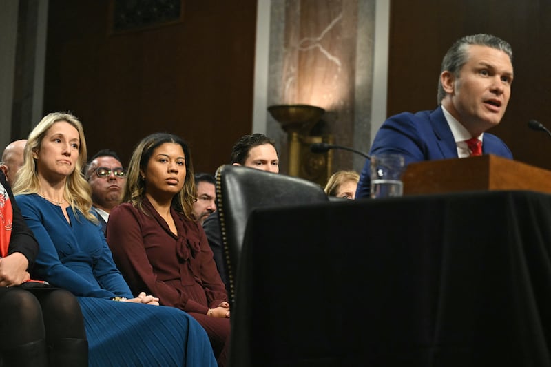 Jennifer Rauchet (L), wife of Pete Hegseth, looks on as he testifies during his confirmation hearing.
