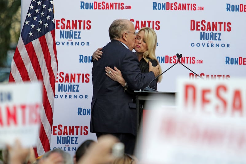 Former mayor of New York City Rudy Giuliani hugs Florida Attorney General Pam Bondi on stage during a rally for Republican gubernatorial nominee Ron DeSantis in Boca Raton, Fla. on the final day of early voting on Sunday, Nov. 4, 2018. (John McCall/Sun Sentinel/Tribune News Service via Getty Images)