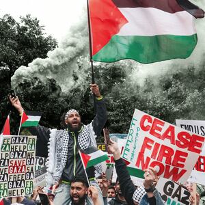 An illustration including a photo of a protester holding a flare and a Palestinian flag during a rally in support of Palestinians at the Texas State Capitol in Austin
