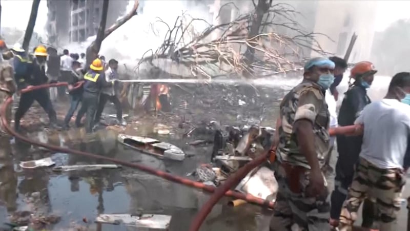Emergency personnel work at the crash site of an Air India plane in Ahmedabad, India, June 12, 2025, in this still image taken from video.