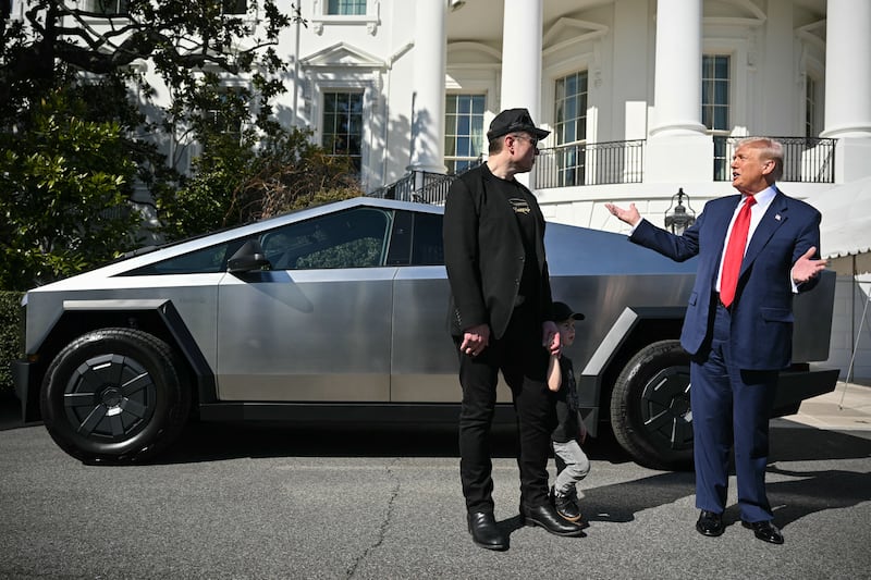 Donald Trump and Tesla CEO Elon Musk speak to the press as they stand next to a Tesla Cybertruck on the South Portico of the White House.