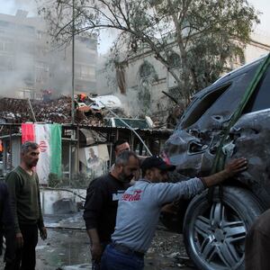 Rescue workers move near the scene of an airstrike in Damascus, Syria.