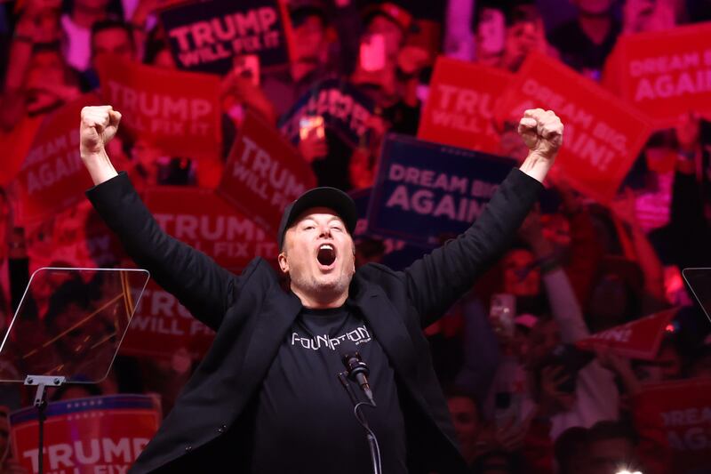 Tesla and X CEO Elon Musk raises his hands as he takes the stage during a campaign rally for Republican presidential nominee, U.S. President Donald Trump, at Madison Square Garden on October 27, 2024 in New York City.