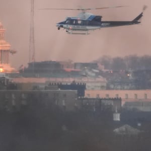A helicopter flies near the crash site of the American Airlines plane.