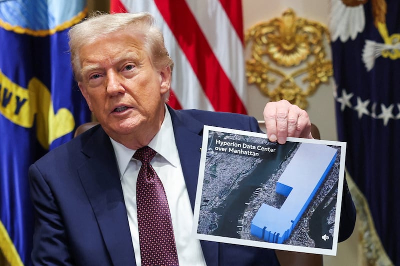 Donald Trump holds a printed-out visual representation reading Hyperion Data Centre over Manhattan, during a cabinet meeting at the White House in Washington, D.C., U.S., August 26, 2025.
