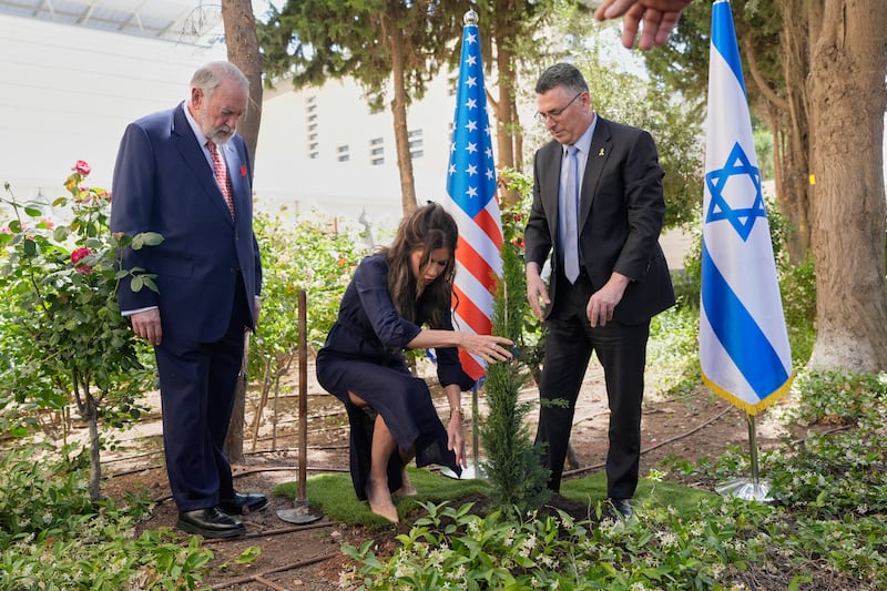 Kristi Noem plants a tree with Israel's Foreign Minister Gideon Sa'ar as U.S. Ambassador to Israel Mike Huckabee looks on in Jerusalem.