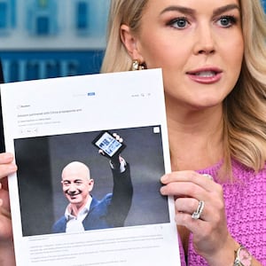 Karoline Leavitt holding a picture of Jeff Bezos