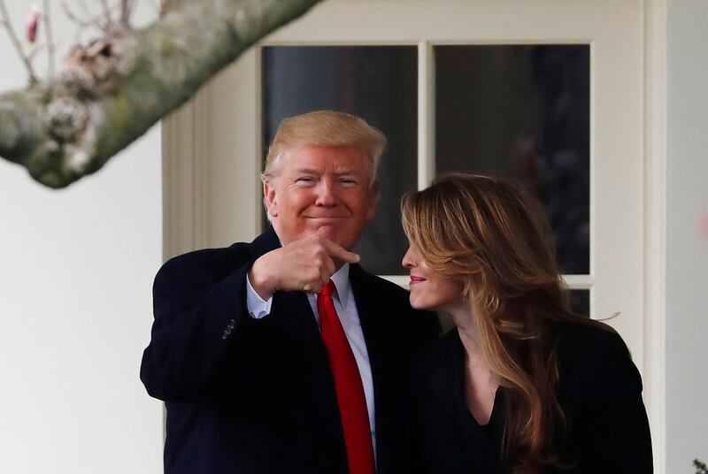 U.S. President Donald Trump reacts as he stands next to former White House Communications Director Hope Hicks outside of the Oval Office as he departs the White House for a trip to Cleveland, Ohio, in Washington D.C., U.S., March 29, 2018. Picture taken March 29, 2018. REUTERS/Carlos Barria