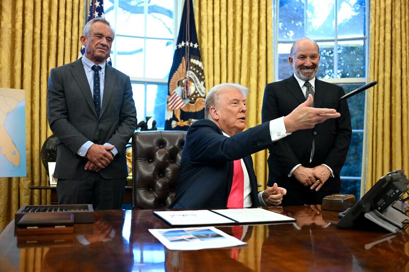 US President Donald Trump throws a sharpie to an aide after signing an Executive Order, alongside US Secretary of Health and Human Services Robert F. Kennedy Jr. (L) and US Secretary of Commerce nominee Howard Lutnick (R), at the Oval Office of the White House in Washington, DC on February 25, 2025.