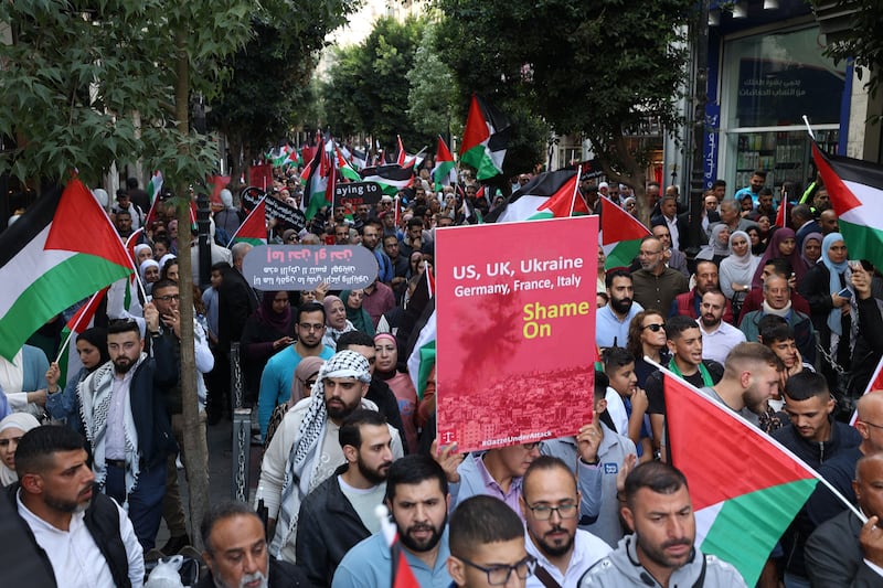 A photo including Palestinians waving the national flag in the West Bank city in Ramallah 