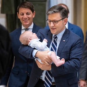 House Speaker Mike Johnson (R-La.) holds the infant son of his chief of staff as he walks to a vote at the U.S. Capitol June 5, 2025.