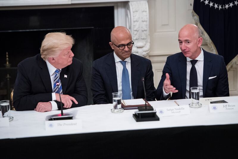 President Donald Trump speaks with Microsoft CEO Satya Nadella (center) and Jeff Bezos during a Council roundtable at the White House in Washington, D.C. on June 19, 2017.