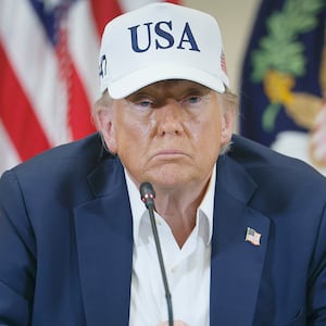 Donald Trump wearing a "USA" baseball cap looks glum during a round table event in Texas in July.