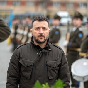 President of Ukraine Volodymyr Zelenskyi stands in front of wreath during memorial ceremony.