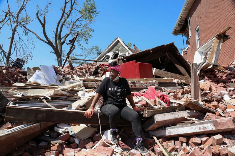 A woman sits on top of the wreckage of her home caused by the tornado in St. Louis