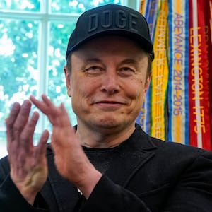 Elon Musk applauds in the Oval Office as he attends a press conference with U.S. President Donald Trump, at the White House
