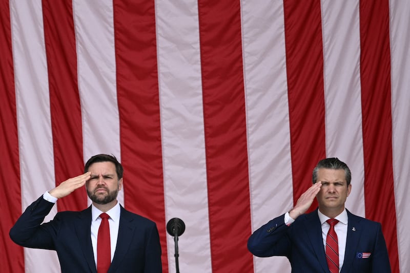 Vice President JD Vance (left) and Secretary of Defense Pete Hegseth salute as the National Anthem is played at the National Memorial Day Observance at the Memorial Amphitheatre in Arlington National Cemetery in Arlington, Virginia, on May 26, 2025.
