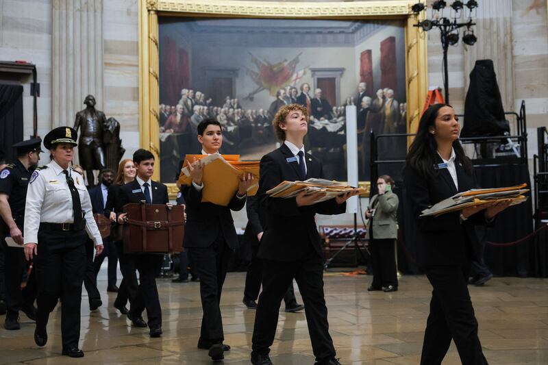 Senate pages carry electoral votes through the Rotunda after a joint session of Congress to certify the results of the 2024 presidential election on January 6, 2025, in Washington, D.C.