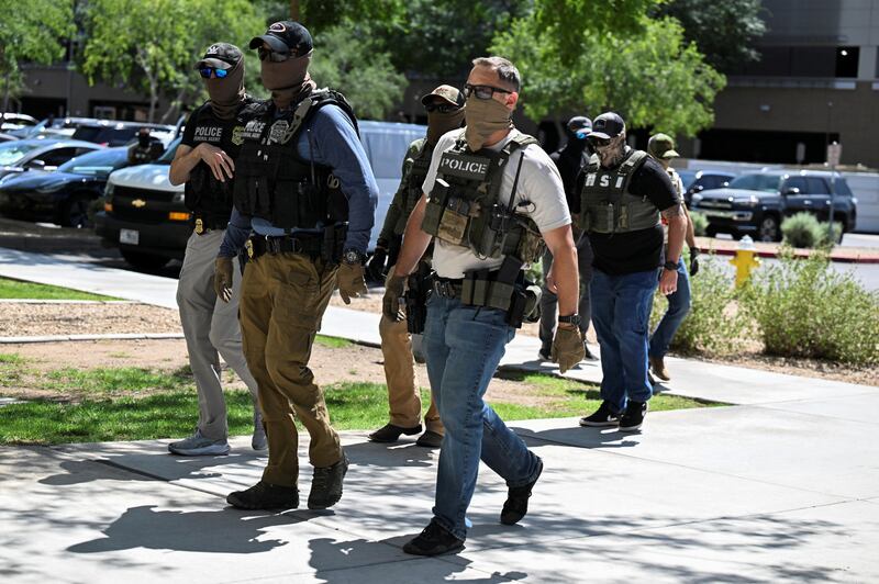 Masked law enforcement officers, including HSI and ICE agents, walk into an immigration court in Phoenix, Arizona, U.S., May 21, 2025.  REUTERS/Caitlin O'Hara