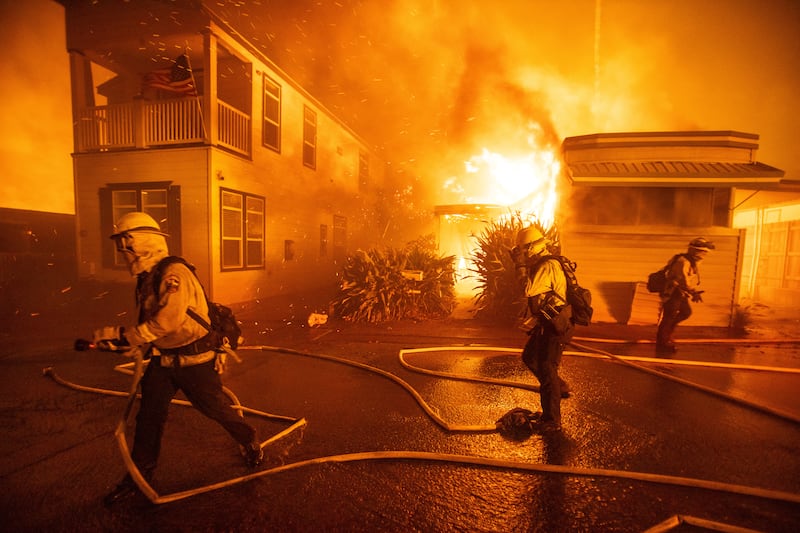 Firefighters battle the Palisades Fire as it burns during a windstorm just west of Los Angeles on Tuesday.