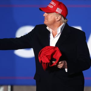 Donald Trump tosses a MAGA hat to the crowd before speaking at a rally at the Canyon Moon Ranch festival grounds on January 15, 2022 in Florence, Arizona.