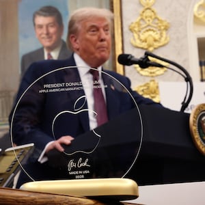 President Donald Trump speaks behind an engraved glass disc gifted to him by Apple CEO Tim Cook during an event in the Oval Office of the White House on August 6, 2025 in Washington, DC.