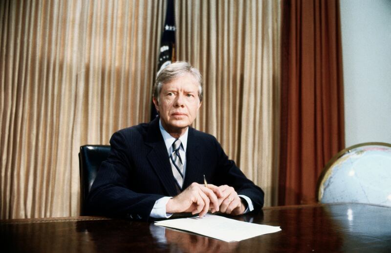 President Jimmy Carter, seated at his desk in the White House Oval Office of White House, alerts the nation to an aborted rescue effort intended to get 53 American hostages out of Iran. Carter said the mission was scrubbed after an "equipment failure."