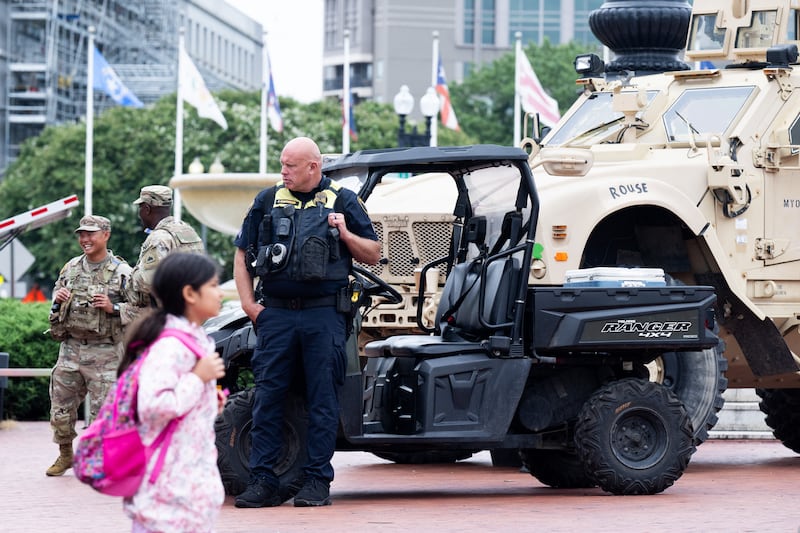 People walk past National Guard members standing watch outside Union Station in Washington, DC, under orders from the Trump administration on August 19, 2025.