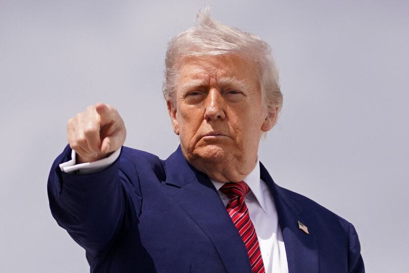 President Donald Trump points as he boards Air Force One en route to New Jersey, at Joint Base Andrews, Maryland