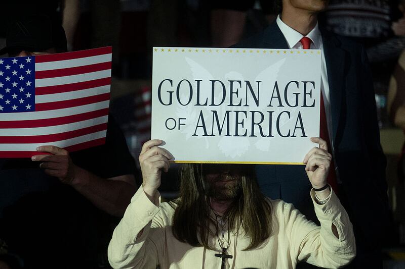 Trump supporters in Michigan waved signs that read “Golden Age of America” during a speech to mark his first 100 days in office Tuesday.