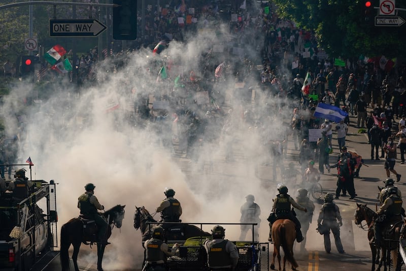 Mounted police operate amid tear gas as people protest during a No Kings Day demonstration in Los Angeles, California.