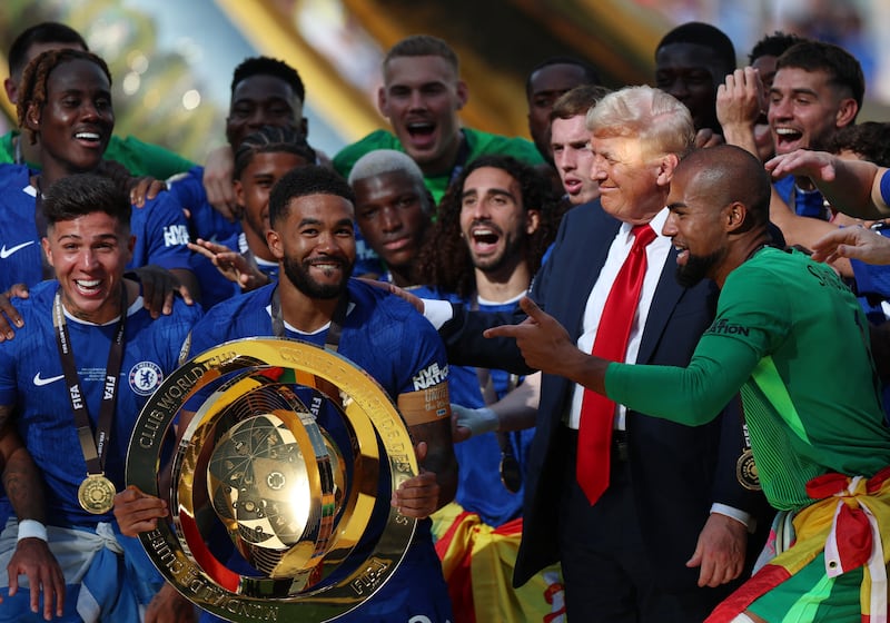 Soccer Football - FIFA Club World Cup - Final - Chelsea v Paris St Germain - MetLife Stadium, East Rutherford, New Jersey, U.S. - July 13, 2025 Chelsea's Reece James and teammates celebrate with the trophy alongside U.S. President Donald Trump after winning the FIFA Club World Cup REUTERS/Hannah Mckay