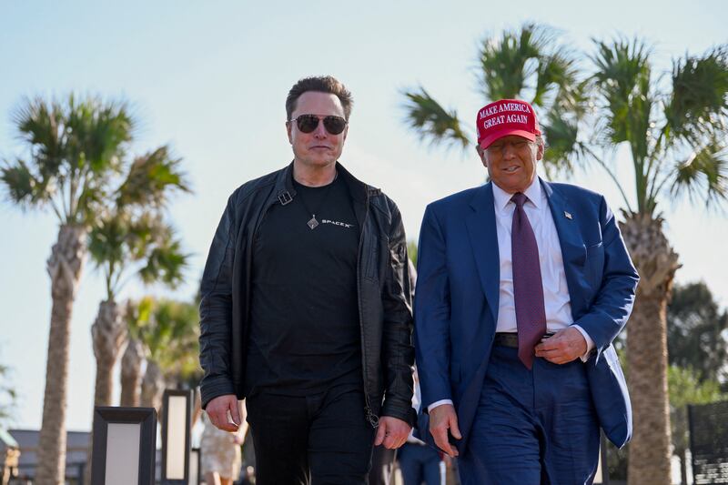 U.S. President-elect Donald Trump walks with Elon Musk.