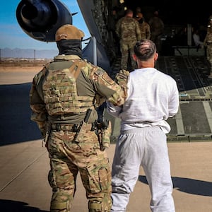 The first U.S. military aircraft to carry detained migrants to a detention facility at Guantanamo Bay, who U.S. Department of Homeland Security spokesperson Tricia McLaughlin called "highly dangerous criminal aliens", is boarded from an unspecified location in the U.S. February 4, 2025  DHS/Handout via REUTERS.  THIS IMAGE HAS BEEN SUPPLIED BY A THIRD PARTY