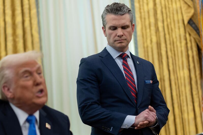 Defense Secretary Pete Hegseth stands by President Donald Trump during a meeting in the White House Oval Office in Washington, D.C., U.S. on March 21, 2025.