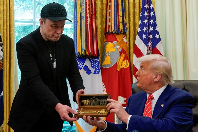 Elon Musk receives the key to the White House from President Donald Trump during a press conference in the Oval Office on Friday. Musk, who sported a black eye during the event, has officially left the Department of Government Efficiency.