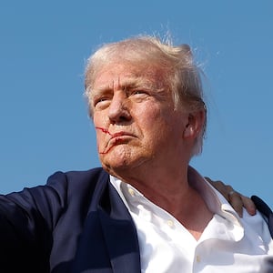 BUTLER, PENNSYLVANIA - JULY 13: Republican presidential candidate former President Donald Trump pumps his fist as he is rushed offstage by U.S. Secret Service agents after being grazed by a bullet during a rally on July 13, 2024 in Butler, Pennsylvania. Butler County district attorney Richard Goldinger said the shooter is dead after injuring former U.S. President Donald Trump, killing one audience member and injuring another in the shooting. (Photo by Anna Moneymaker/Getty Images)